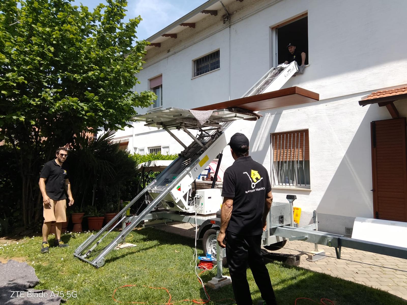 Operatore Montorsi imballa un mobile in legno con coperte protettive